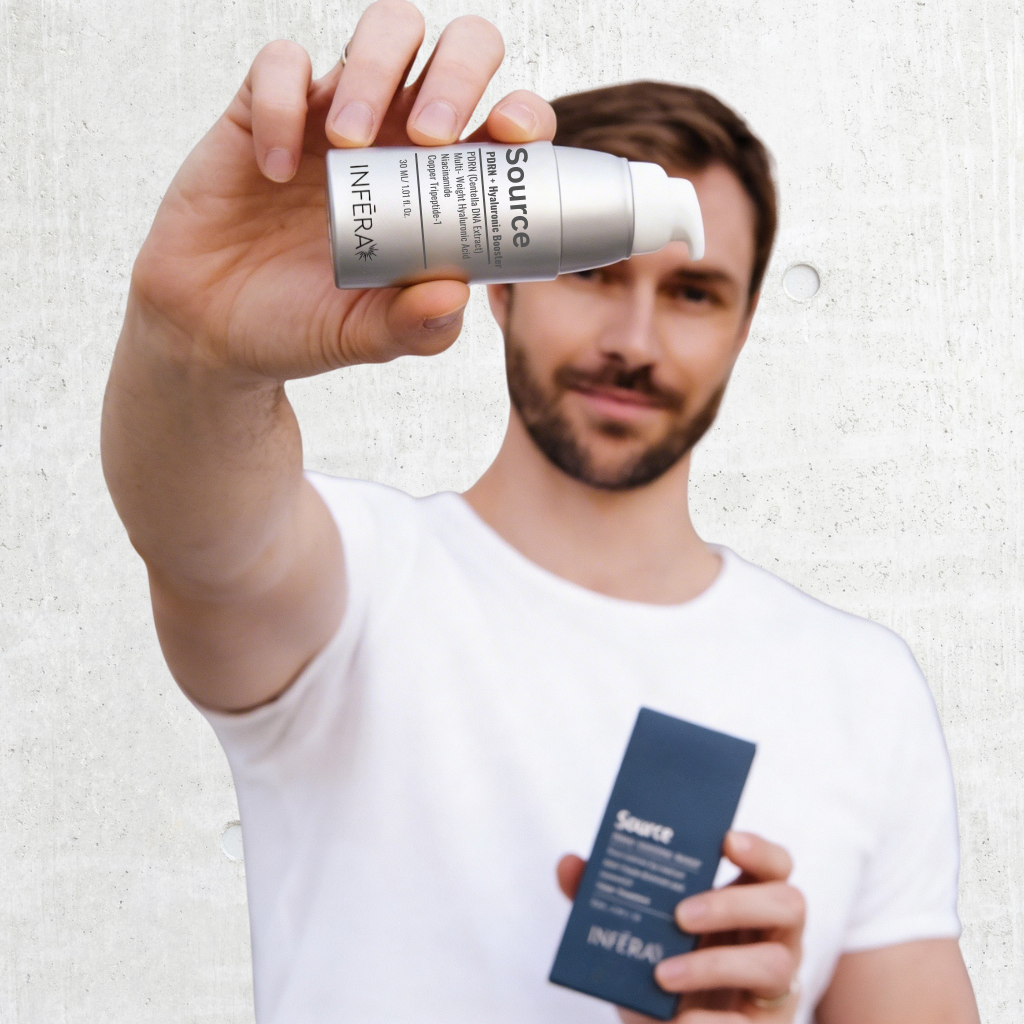 Man holding a skincare product labeled &