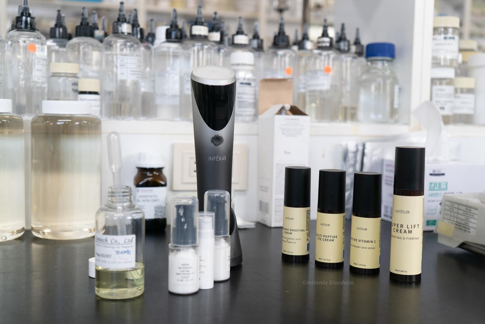 Various INFERA skincare products on a counter with a blurred background of more products.